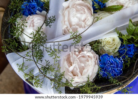 Flower arrangement of white peony, roses and blue carnations