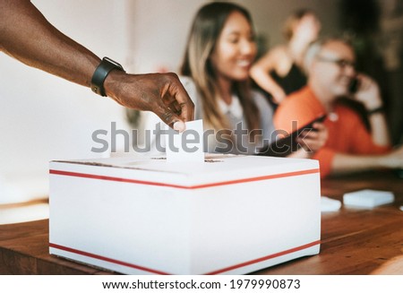 Black man casting his vote to a ballot box Royalty-Free Stock Photo #1979990873