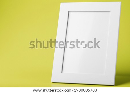 White photo frame on yellow background with free space. Minimalistic concept