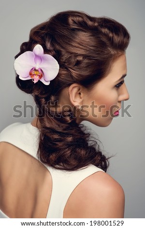 Beautiful bride with fashion wedding hairstyle. Orchid flower 
