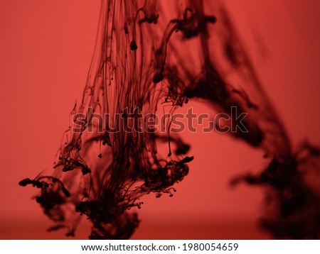 Ink Drop Black ink drifting in the water with red lights