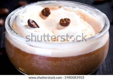 
Vanilla affogato topped with hot coffee on a black wood background 