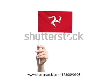 Beautiful female hand holding Isle of Man flag, isolated on white background.