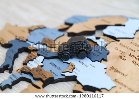 Toy car on a wooden map background. Automobile travel and tourism concept. Europe close up
