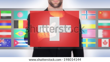 Hand pushing on a touch screen interface, choosing language or country, Switzerland