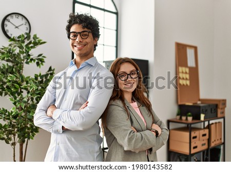 Two business workers smiling happy with arms crossed gesture at the office. Royalty-Free Stock Photo #1980143582