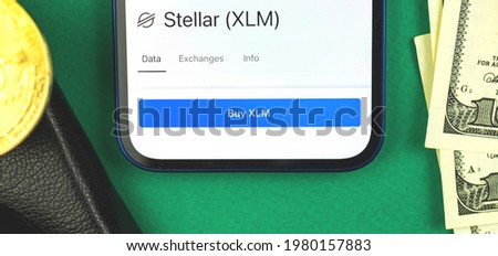 Stellar XLM crypto currency symbol on the screen of mobile phone, trade and exchange concept banner, top view 