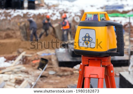 Laser rangefinder at a construction site. Measuring tool at a construction site. Accurate construction site measurement equipment