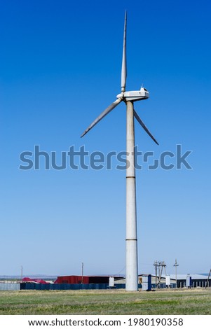 Wind turbine near a large agricultural farm. The picture was taken in Russia, in the Orenburg region