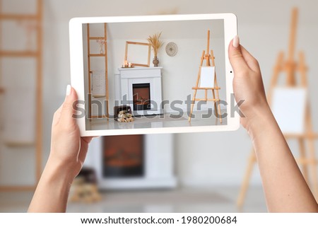 Woman taking photo of fireplace in room