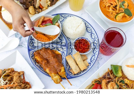 Assorted Thai food in flat lay composition, Thai Food Mixed Dishes, Asian food rice noodle served with chicken in Teriyaki sauce and sesame seeds, top viewAssorted Thai food in flat lay composition, 
