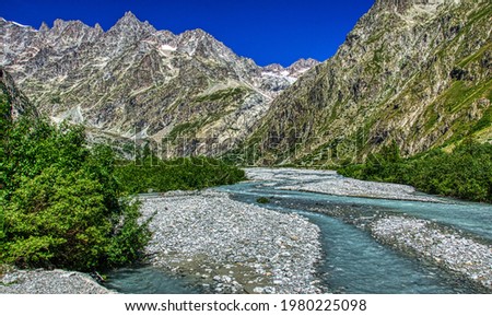 The waters of the Torrent de Saint Pierre in the vicinity of the Pre de Madame Carle located in the commune of Vallouise, within the national park des Ecrin, Hautes Alpes department, France. HDR image Royalty-Free Stock Photo #1980225098