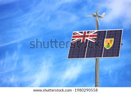 Solar panels against a blue sky with a picture of the flag of Turks and Caicos Islands
