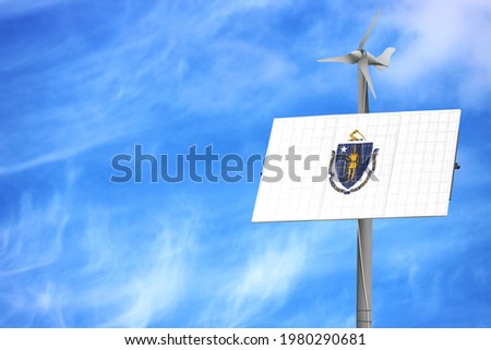 Solar panels against a blue sky with a picture of the flag State of Massachusetts
