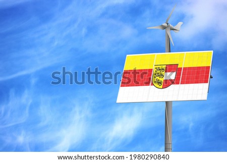 Solar panels against a blue sky with a picture of the flag of Carinthia