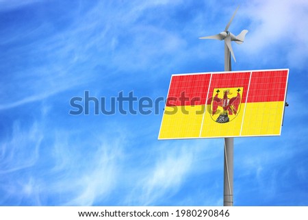 Solar panels against a blue sky with a picture of the flag of Burgenland