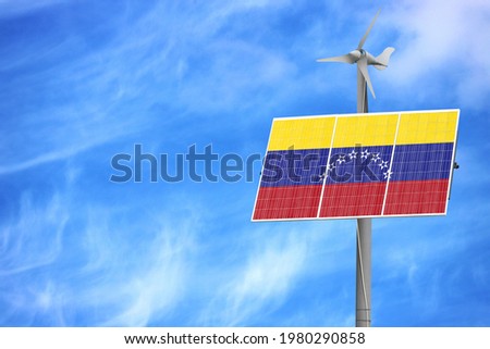 Solar panels against a blue sky with a picture of the flag of Venezuela