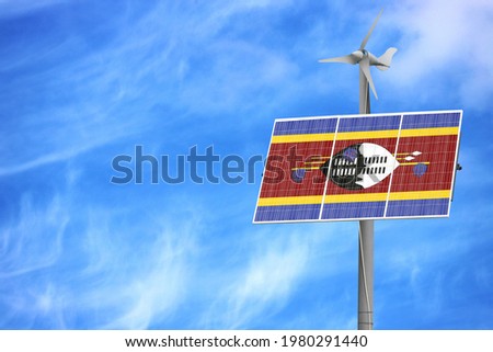 Solar panels against a blue sky with a picture of the flag of Swaziland