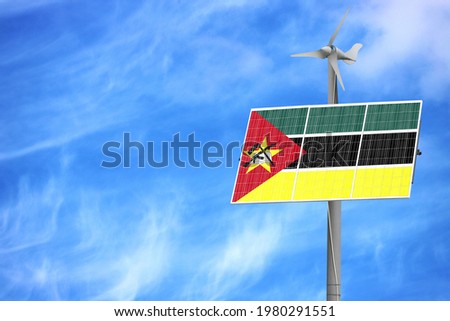 Solar panels against a blue sky with a picture of the flag of Mozambique