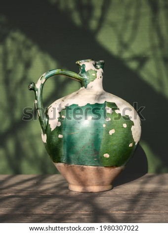 A very old ceramic jug with peeling paint. Vintage. Minimalism.