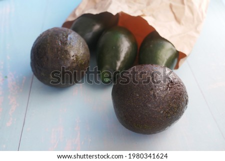 close up of slice of avocado on wooden table 