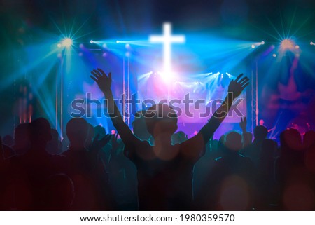 Christians raising their hands in praise and worship at cross background