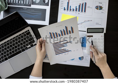 The head sales department checks the monthly sales datasheet for the salesperson to calculate the monthly commission, she looks at the document and presses the calculator. Sales management concept Royalty-Free Stock Photo #1980387407