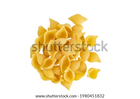 Uncooked dried conchiglie. Raw organic shell pasta. Heap of traditional Italian seashells pasta isolated on a white bachground. Italian Cuisine. Top view. Copy space. Royalty-Free Stock Photo #1980451832
