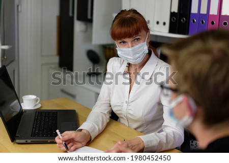 Photo adult caucasian woman in mask in business office talking with client