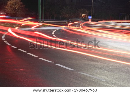 The junction of two roads, light traces from the car. Picture was taken at night on a slow shutter speed