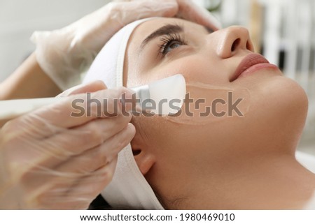 Young woman during face peeling procedure in salon, closeup Royalty-Free Stock Photo #1980469010