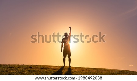Strong powerful young determined man with fist up to the sky. Never giving up, and physical and inner strength. 
 Royalty-Free Stock Photo #1980492038