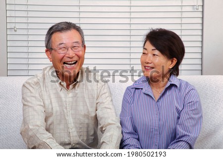 Japanese senior couple smiling at the camera Royalty-Free Stock Photo #1980502193
