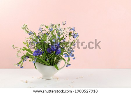 Home interior with decor elements, beautiful spring garden flowers in a vase on a light background, abstract flower arrangement, still life with place for text, floral card for birthday, wedding, 
