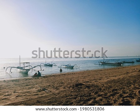 This picture is taken from Sanur beach which is located on the island of Bali. Seen rows of fishing boats anchored.