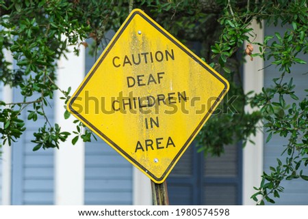 Bent and Worn "Caution Deaf Children in Area" Sign in Uptown neighborhood in New Orleans, Louisiana, USA