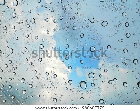 Raining with rainbow on glass window background
