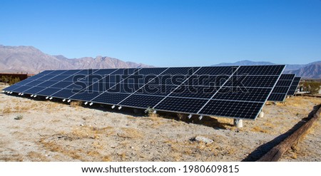 A large rack with solar panels on the ground.
