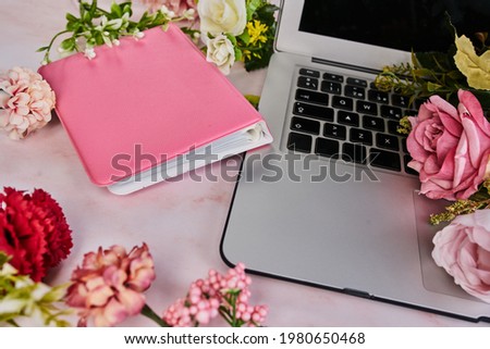 Laptop with a pink photo album, feminine concept