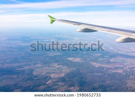 View from the airplane window at a beautiful blue sunrise and the airplane wing in clear sky. Earth and sky as seen through window of an airplane.