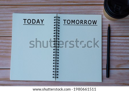 Today tomorrow text written on notepad with pen and cup of disposable coffee on wooden table Royalty-Free Stock Photo #1980661511