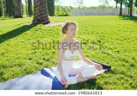   woman in White meditating in park. yoga time. relaxation outdoor. summer activity. healthy lifestyle. keep calm and breath.            