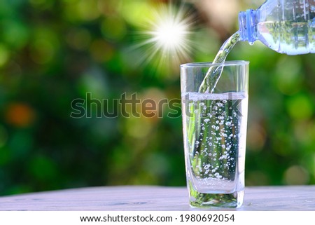 Water flows into a glass on table and mineral water health care concept, space for text