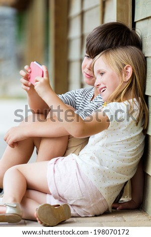 Summer scene of Happy young brothers taking selfies with her smartphone in the park