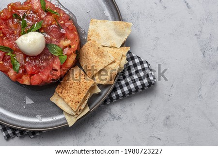 Homemade Tomato Carpaccio Salad with Mozzarella, olive oil and Basil with Arabic Bread. Healthy food concept