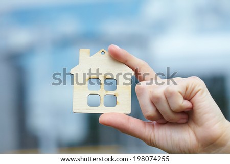 hand with wood house