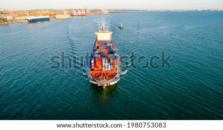 Aerial in front view of cargo ship with contrail in the ocean sea ship carrying container and running for export from international port to custom ocean concept freight shipping by ship service