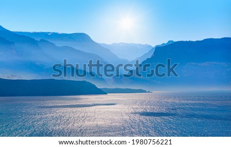 Amazing blue mountains over the blue seav with gorgeous blue sky in the background