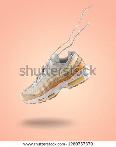 Woman Sneaker on peach color background, woman fashion, sport shoe concept, floating idea, air, product photography, trending shoes, street wear