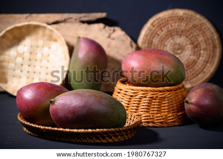 Fresh palmer mango in a basket on black background, Tropical fruit
